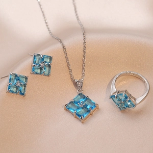 Vista dettagliata del set di gioielli in argento con gemme geometriche blu su raso