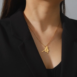 Golden stainless steel necklace featuring a gymnast silhouette pendant worn by a model