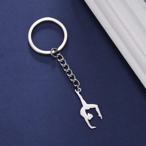 Porte-clés gymnaste en acier inoxydable poli avec anneau rond sur un fond bleu mat