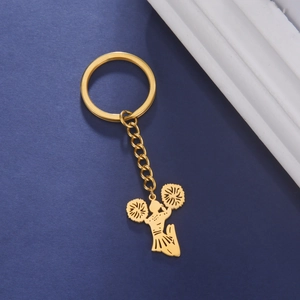 Golden cheerleader silhouette keychain on dark blue background with elegant props