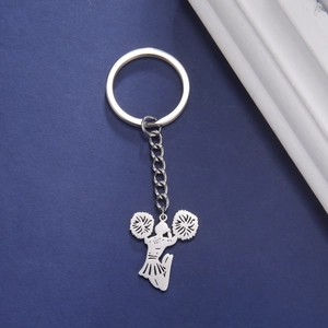 Macro shot of silver stainless steel cheerleader silhouette keychain on blue background