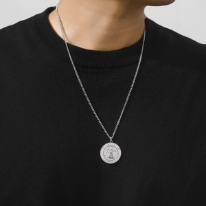 Gros plan d'un collier pendentif zodiaque Sagittaire en argent sur un mannequin homme