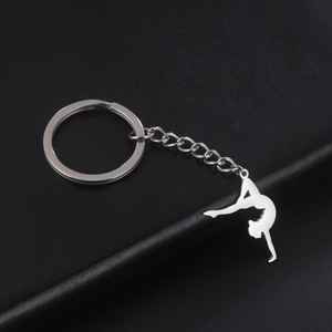 Macro shot of silver gymnast silhouette keychain with polished finish on black surface