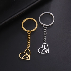 Détail de porte-clés en forme de cœur avec silhouette de gymnaste en or et argent