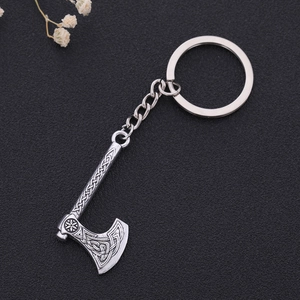 Creative zinc alloy Viking axe keychain with intricate Celtic knot patterns on a black surface