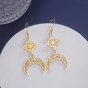 Detail of gold Celtic witch knot earrings with hollow crescent moon and vintage patterns