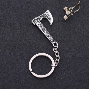 Vintage silver Viking axe keychain with Nordic knot engravings on dark grey background