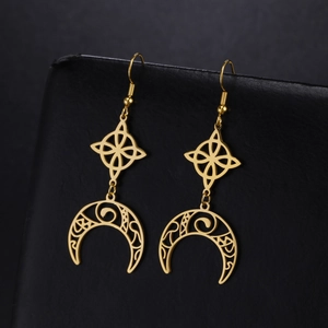 Detail of golden Celtic knot and crescent moon hollow earrings on dark leather display