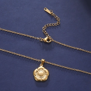 Macro shot of gold stainless steel necklace featuring a five-petal flower charm and lobster clasp