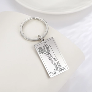 Détail de la gravure de la carte de tarot L'Ermite sur un porte-clés en acier poli