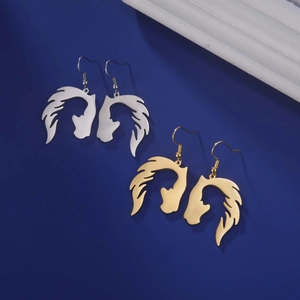 Dettaglio di orecchini a silhouette testa di cavallo in oro e argento su sfondo blu