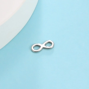 Detailed macro shot of silver infinity symbol pendant in polished stainless steel finish