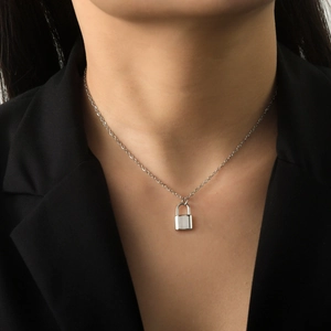 Macro shot of silver padlock pendant on o-chain worn with a professional black blazer