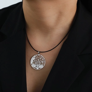Detail of silver Egyptian Ankh Eye of Horus pendant on black cord over dark suit