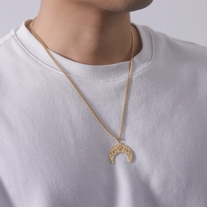 Detailed view of a gold crescent moon pendant with镂空 patterns worn by a male model