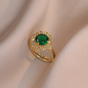 Detailed macro view of an elegant gold flower ring with a green emerald zircon
