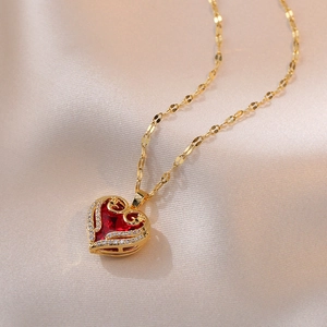 Collier cœur doré romantique avec cristal rouge et diamants sur tissu en soie chic