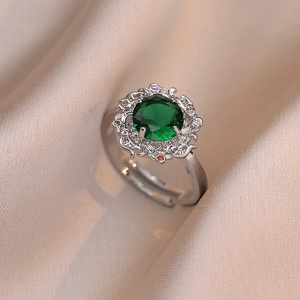 Macro view of vintage silver ring with emerald zircon and colorful hollow filigree details