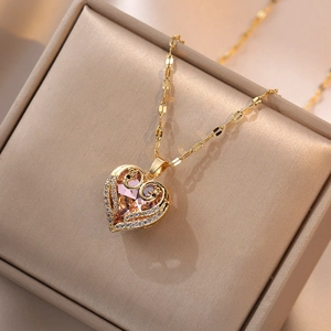 Détail d'un collier cœur en cristal rose avec des accents de paons et zircons fins