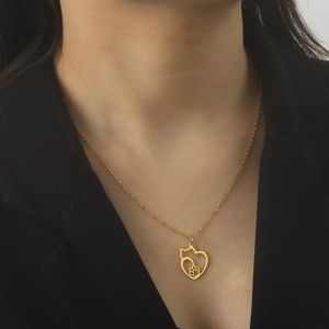 Golden stainless steel necklace with hollow heart and cat silhouette worn on model