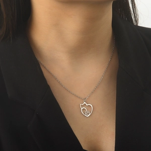 Detailed view of silver heart pendant with cat silhouette and paw print on model