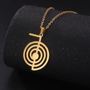 Nahaufnahme des goldenen Cho Ku Rei Reiki-Symbols an einer minimalistischen Edelstahlkette