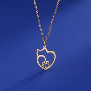 Detail shot of the golden heart necklace with hollow cat and paw print pendant charms