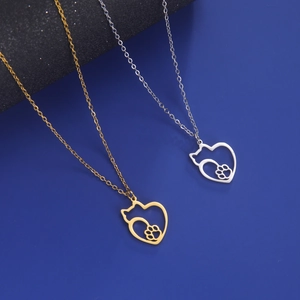 Close-up of heart-shaped cat paw hollow pendants in gold and silver stainless steel