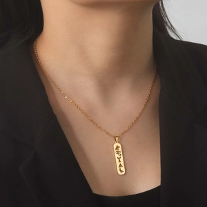 Collana minimalista in acciaio dorato con pendente rettangolare e incisioni egizie