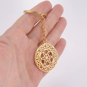 Golden stainless steel keychain featuring a hollow geometric flower pendant in hand