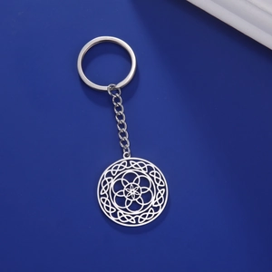 Detailed close-up of a silver stainless steel keychain with a geometric mandala pendant