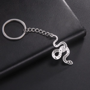 Polished stainless steel snake keychain with star and moon hollow patterns on a black background