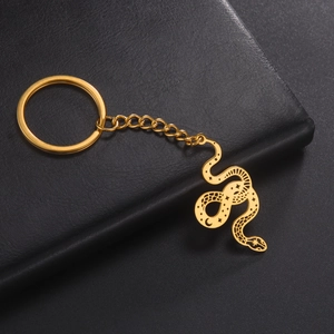 Detailed view of golden snake keychain featuring celestial star and moon engravings