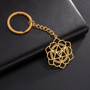 Detail of a golden mandala flower hollow pendant keychain on a dark leather surface