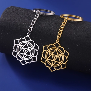 Detailed close-up of geometric lotus and Merkaba pendants in silver and gold steel finish