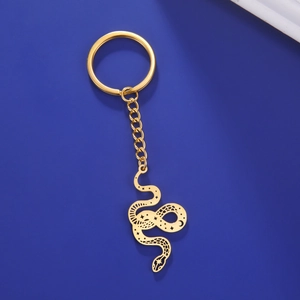 Close-up of golden stainless steel snake keychain with celestial star and moon patterns