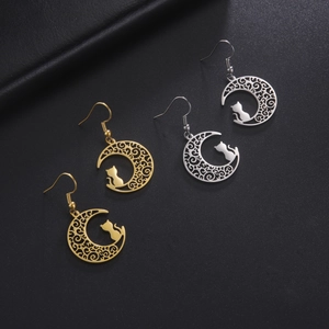 Detail of hollow moon and cat drop earrings in gold and silver finish on leather