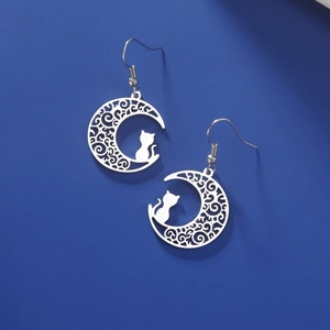 Detailed view of cutout moon and cat pendant earring with elegant filigree patterns