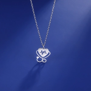 Detailed view of stethoscope heart pendant with EKG line on polished steel chain