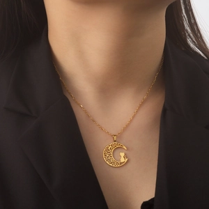 Chic golden moon and cat pendant necklace in stainless steel shown on female model