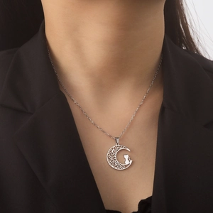Detail of moon cat pendant necklace worn on a black blazer for a professional look