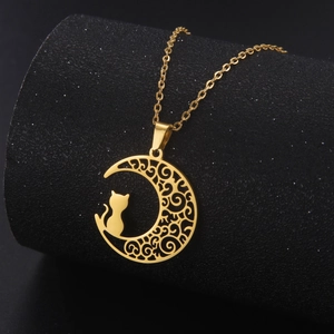 Detailed close-up of gold moon and cat pendant with fine chain on black display