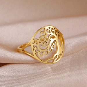 Macro di anello dorato con motivo albero della vita su tessuto di seta champagne