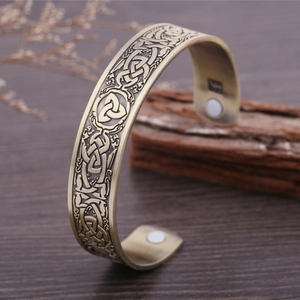 Detail of Celtic knot engraving and Triquetra symbol on vintage bronze magnetic bracelet