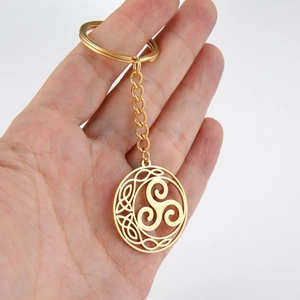 Golden stainless steel Celtic Triskele knot keychain with chain in hand view