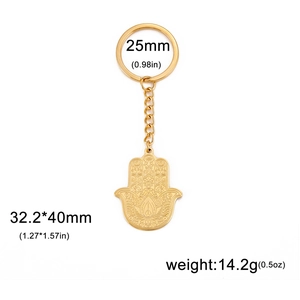 Vue détaillée du porte-clés main de Hamsa doré avec motifs floraux et gravure de lotus
