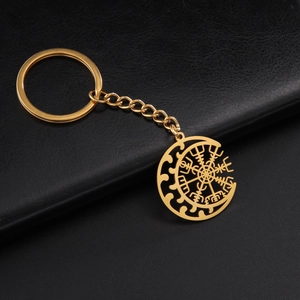 Macro shot of a golden stainless steel keychain with Viking Vegvisir and moon pendant