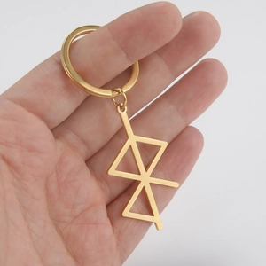Golden stainless steel keychain with minimalist geometric rune pendant held in hand