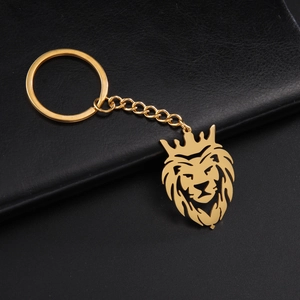 Gros plan d'un pendentif tête de lion dorée polie avec couronne sur fond de cuir noir