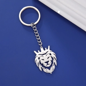 Gros plan du pendentif tête de lion couronnée en argent poli avec anneau et chaîne en acier